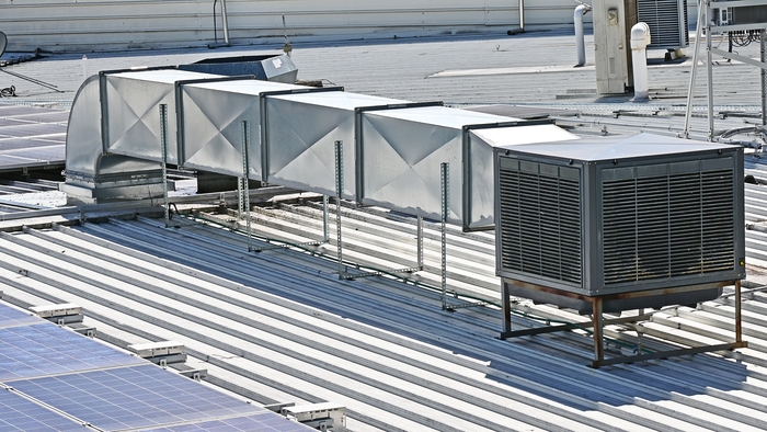 A commercial evaporative cooler at the top of the roof